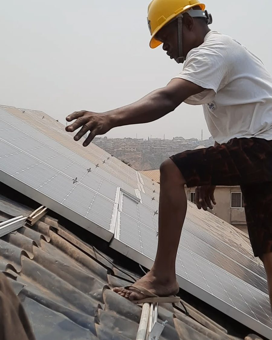A Trewbless technician bolting solar panels to a corrugated roof.