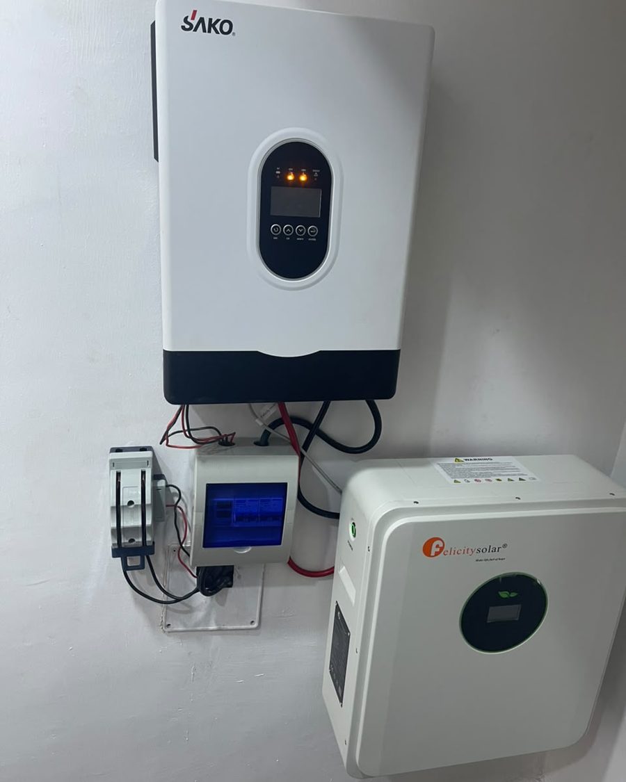 A SAKO hybrid inverter mounted on the wall beside a Felicity Solar battery.